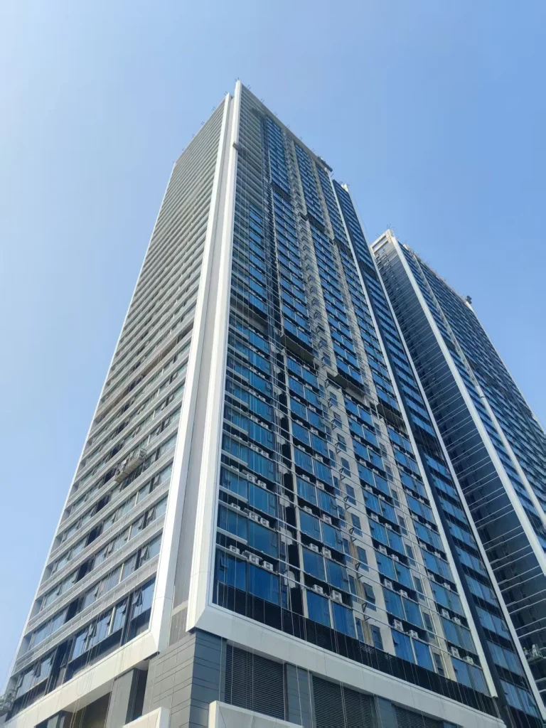 High-resolution late-stage view of the blue-glazed unitized facade on the Foshan Tianyue towers