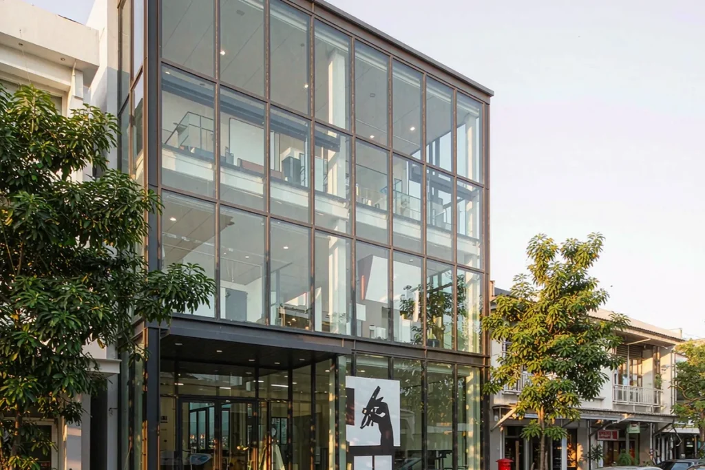 Three-storey design studio with charcoal stick curtain wall and a double-height glazed entrance