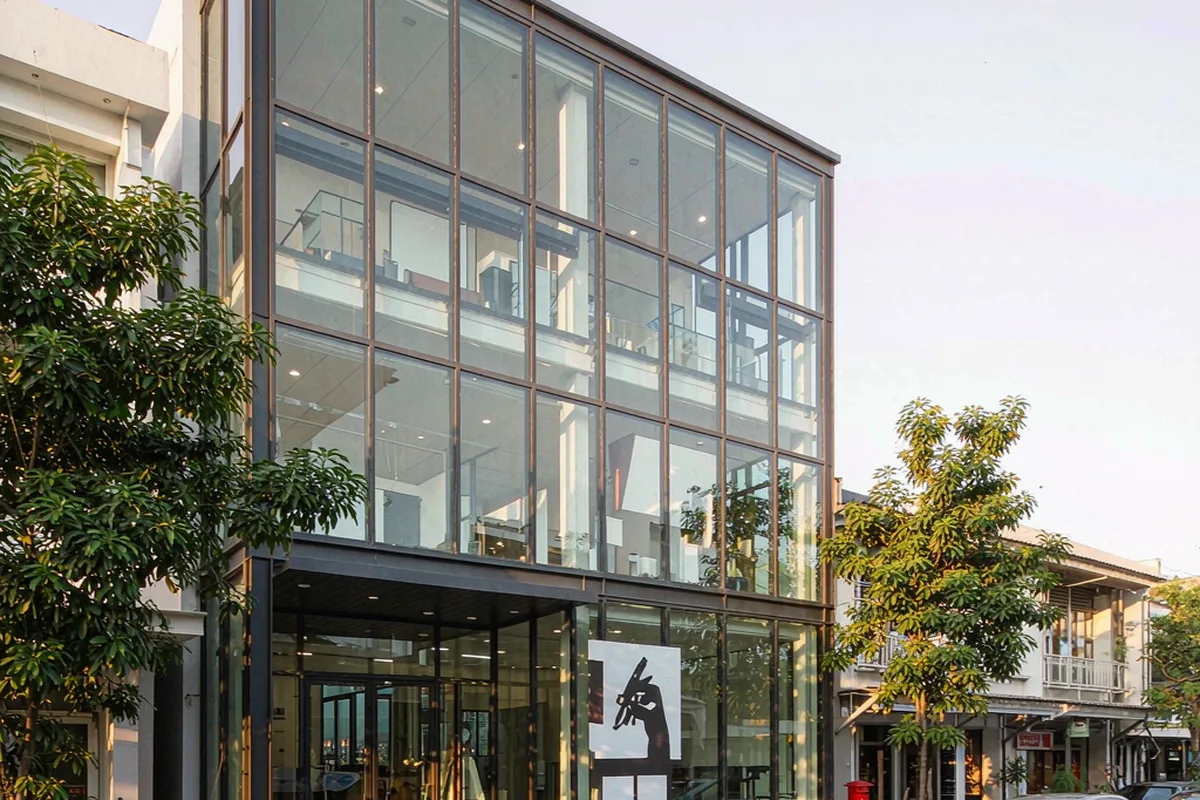 Three-storey design studio with charcoal stick curtain wall and a double-height glazed entrance
