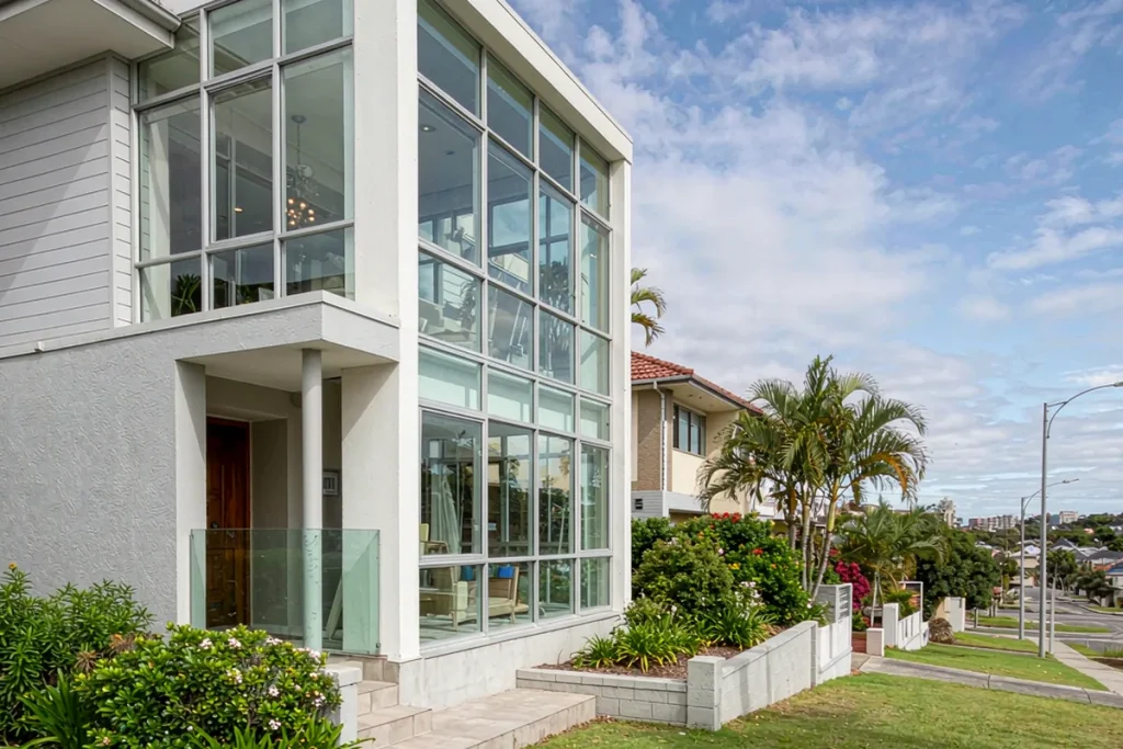 Two-storey suburban house with a modular unitized glass facade of clean repeated panels