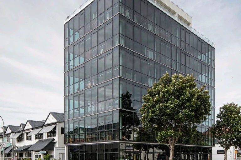 Six-storey corner apartment building with a stick curtain wall facade and ground-floor retail glazing