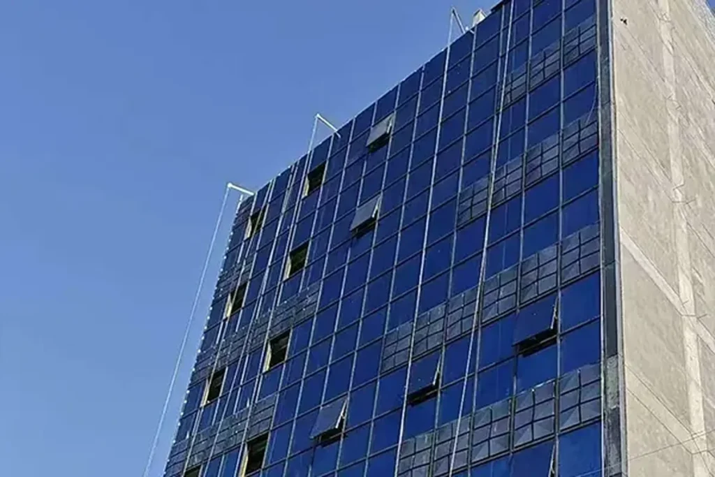 Completed stick curtain wall facade on a three-storey commercial building in Baghdad Iraq, delivered under a single design supply and installation contract