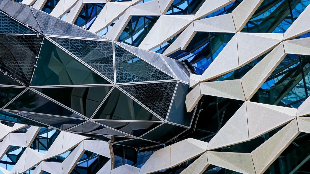 Layered geometric shading over a glazed facade in Saudi Arabia