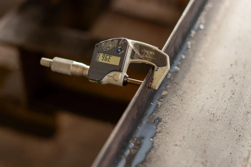 Digital micrometer checking the thickness of a metal component