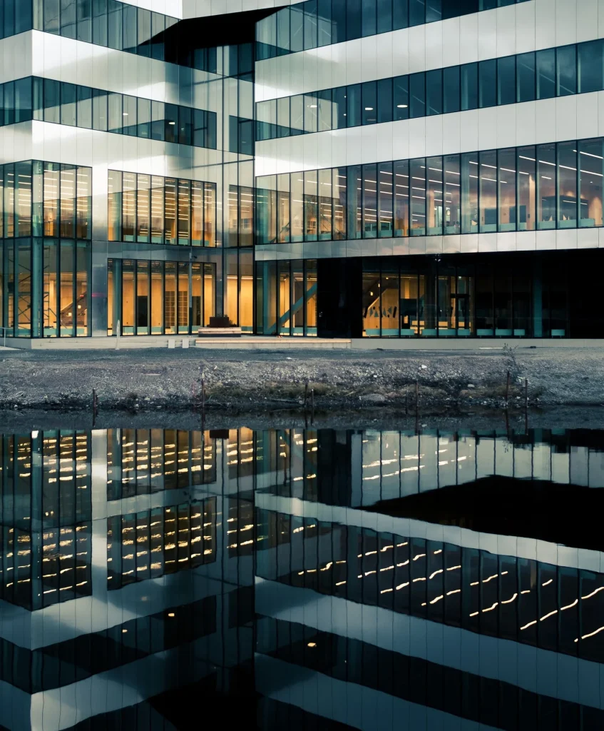 Completed contemporary commercial glass facade illuminated at dusk