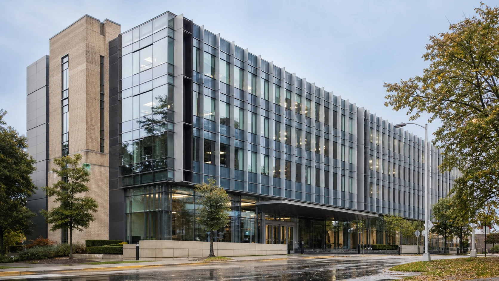 Completed institutional facade renovation integrating retained masonry with a new high-performance curtain wall
